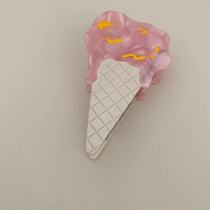 Detail of creative cream ice cream hair claw clip with pink acetate and yellow stripe