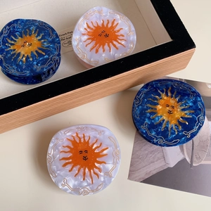 Set of sun-patterned acetate hair claws in dark blue marble and pearlescent white finish