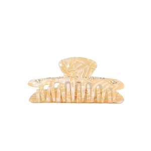 Detailed macro view of cream marble acetate hair claw clip with rhinestones and metal spring