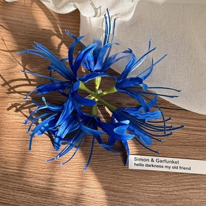Detailansicht der handgefertigten blauen Lycoris-Haarklammer auf Holzuntergrund