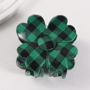 Detail shot of the green and black plaid four-leaf clover hair claw clip with glossy finish