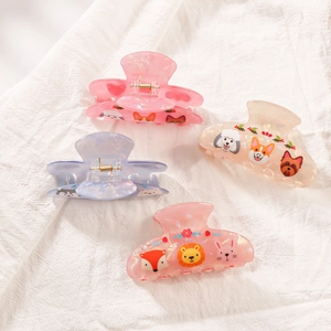 Lot de quatre pinces à cheveux pastel aux motifs animaux sur un tissu en lin naturel