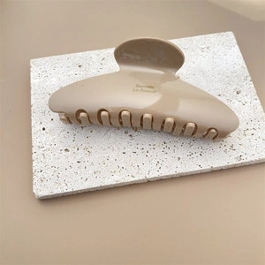 Détail de la pince à cheveux beige minimaliste en acétate avec texte Barrette La France
