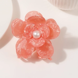 Close-up of pink marble acetate flower hair claw with a white pearl center detail