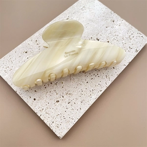 Vue détaillée de la pince à cheveux en acétate marbré crème avec texte Barrette La France