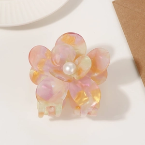 Macro shot of elegant floral hair claw clip featuring pink marble texture and pearl center