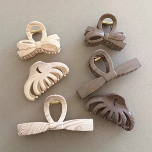 Set of 6 marble textured hair claws in cream and brown with bow and wave designs
