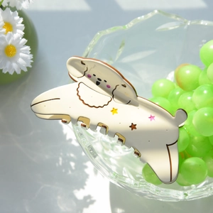 Dettaglio del fermaglio per capelli a forma di cucciolo crema con stelle colorate e fiori