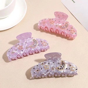 Three-piece marble acrylic hair claw set with gold moon and star rhinestone accents