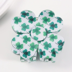 Floral hair claw clip with green clover patterns and glossy finish on a white background
