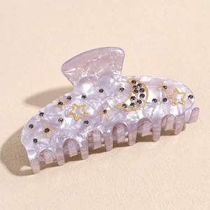 Detail of lilac marble hair claw clip with golden moon, stars, and dark rhinestones