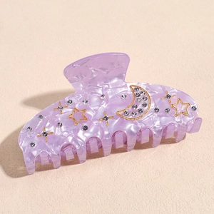 Detailed macro view of light purple marbled hair claw clip with gold star and moon patterns