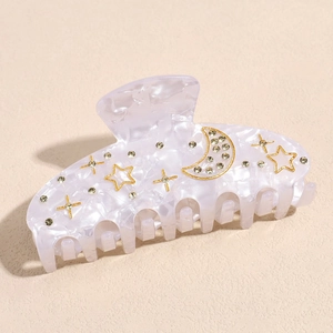 Detail of purple acetate hair claw clip with golden moon, stars and rhinestones inlay