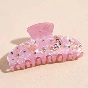 Macro shot of pink marble hair claw clip with star and moon rhinestone accents