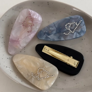 Lot de quatre barrettes en acide acétique à motifs marbrés et décorations en strass