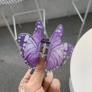 Dettaglio della molletta per capelli a farfalla viola sfumato con venature e molla dorata