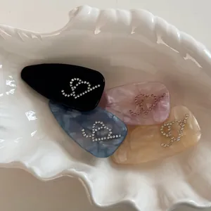 Lot de quatre barrettes en acétate avec motifs marbrés et strass brillants décoratifs