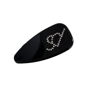 Pince à cheveux goutte d'eau noire brillante avec lettre D en strass au style épuré