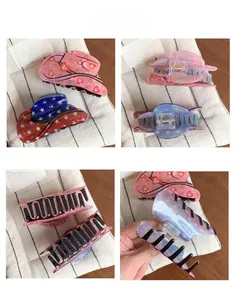 Detail of cowboy hat claw clips with heart and star prints in pink and red-blue