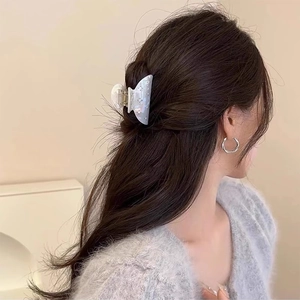 Elegante molletta per capelli in acetato blu con trama a conchiglia e strass su modella