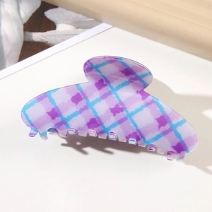 Detail of large purple and blue checkered hair claw clip with a glossy jelly texture