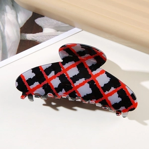 Detailed view of vintage plaid hair claw clip with glossy red black and white checkered pattern