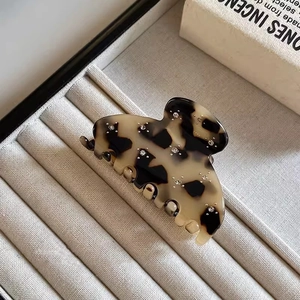 Dettaglio della pinza per capelli leopardata con strass su vassoio per gioielli