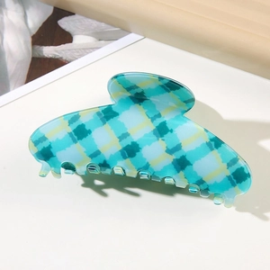 Close-up of a large blue and yellow plaid claw clip with a glossy acetate finish