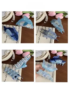 Detailed views of blue dolphin hair claws showing polished texture and metal spring structure