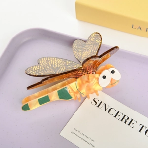 Detail of vintage acetate dragonfly hair claw clip with translucent orange and amber textures