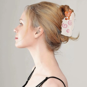Detail showing bear hair claw clip with red swirl patterns on a hair bun