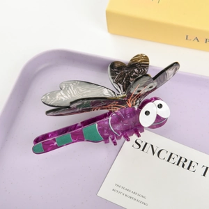 Macro detail of a dragonfly hair claw clip made of purple marble acetate with large eyes
