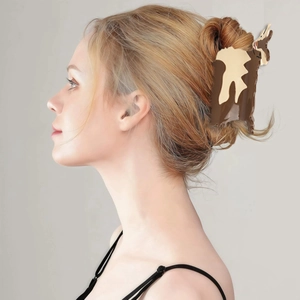 Brown and beige animal print acetate hair claw clip worn by a model in a ponytail