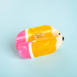 Detail of creative yellow pencil hair claw clip with pink eraser end and black tip