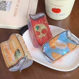 Three cute juice box hair claws with pineapple cherry and orange patterns in a porcelain dish