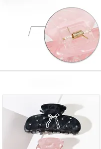 Detail view of acetate hair claws featuring rhinestone bows and custom gold springs
