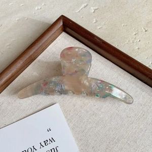 Macro detail of a large acetate hair claw clip with a colorful terrazzo confetti pattern