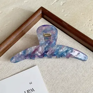 Macro shot of elegant acetate hair claw with dreamy purple and blue marble pattern