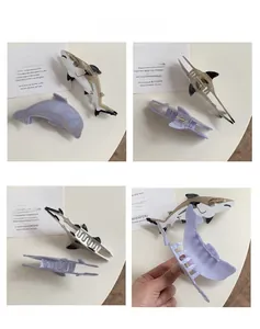 Detailed macro view of shark and dolphin acetate hair claws with sturdy metal spring mechanism