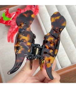Detail view of tortoiseshell dinosaur hair claw clip with sturdy black metal spring mechanism