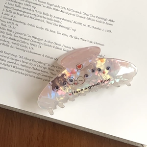 Gros plan sur la pince à cheveux rose irisée avec motifs de chats mignons et texte