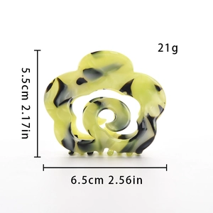 Detail of flower-shaped acetate hair claw with yellow and black marble texture