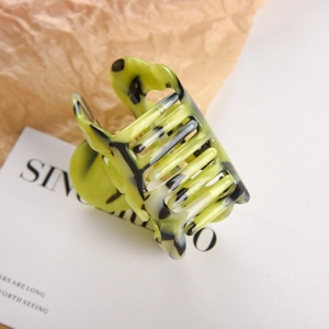 Macro shot of a hollow rectangular acetate hair claw clip with green marble texture