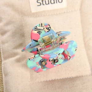 Detail of large acetate hair claw clip featuring a vibrant multi-color terrazzo pattern