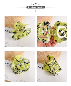 Detail view of flower-shaped acetate claw clip with marble texture and metal spring