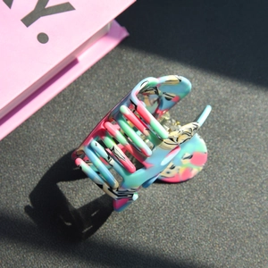 Detail of colorful acetate hair claw clip with artistic ink texture and hollow shark design