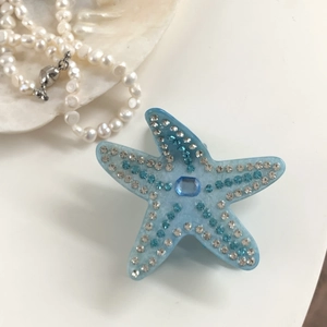Détail de la pince à cheveux étoile de mer bleue avec strass et gemme centrale
