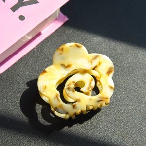 Detailed close-up of cream floral acetate hair claw with brown tortoise shell pattern
