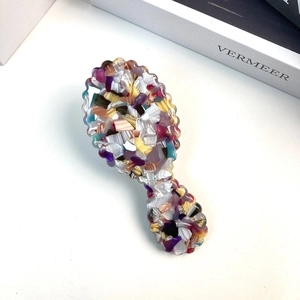 Detailed macro view of acetate hair comb featuring vibrant purple and orange marble texture