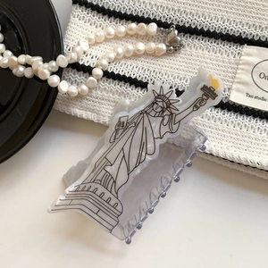 Detail of a minimalist Statue of Liberty acetate hair claw clip with black and white accents